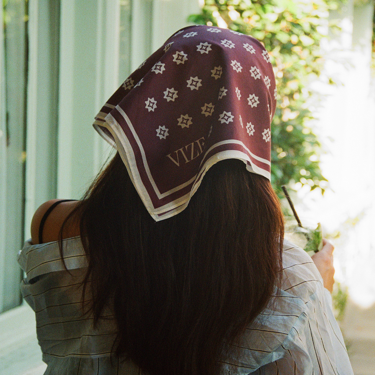 cotton scarf tied around womens head, showing the back of her head and the scarf with white starburst patterns