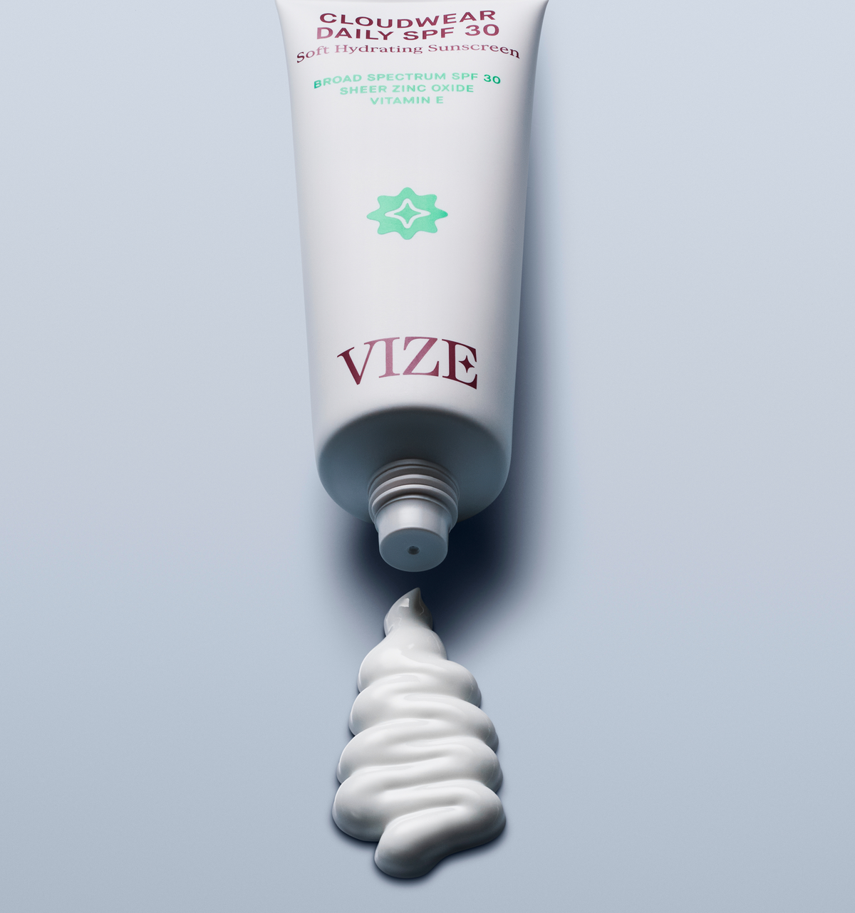 tube of cloudwear daily spf 30 laying on a blue background with a squiggle of product squeezed out of the tube